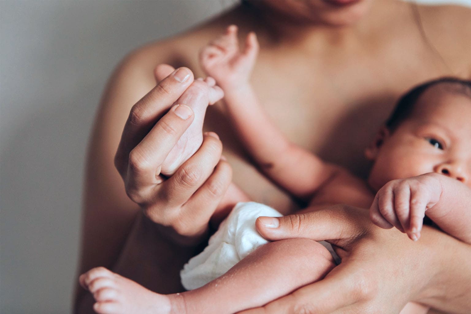 maman tenant son nouveau-né dans les bras après la naissance peau à peau moment maternite allaitement ou biberon