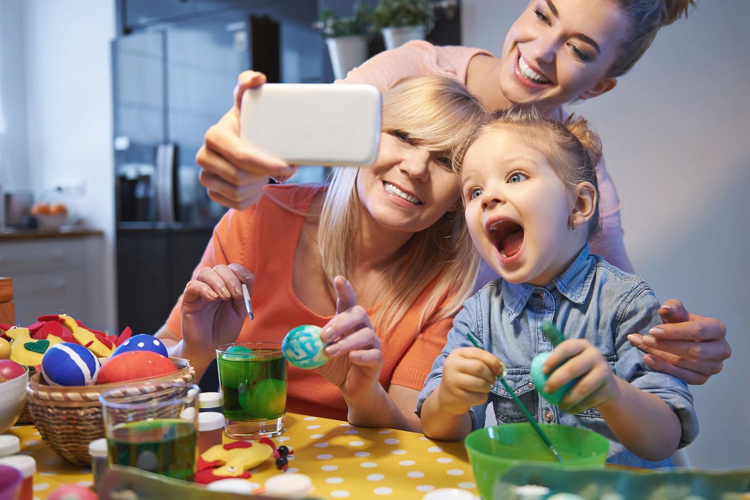 Activité de Pâques en famille avec enfants décorant des œufs colorés autour d’une table