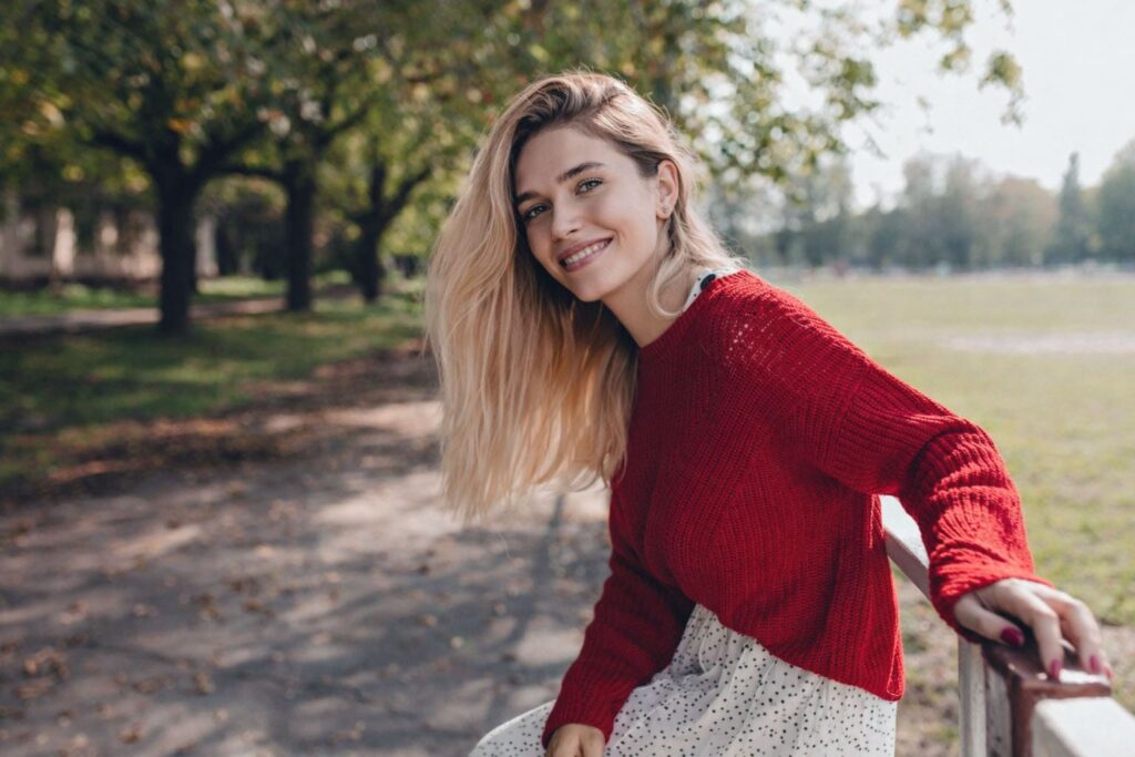 Femme épanouie en extérieur, sourire naturel, illustration de la slow maman qui prend le temps d’exister